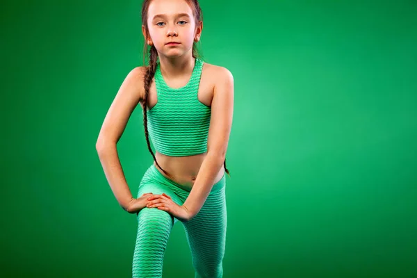 Menina fazendo exercícios de fitness no fundo verde — Fotografia de Stock