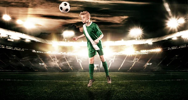 Niño - jugador de fútbol. Niño adelante en ropa deportiva de fútbol en el estadio con pelota. Concepto deportivo . —  Fotos de Stock
