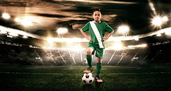 Dziecko - gracz piłki. Chłopiec do przodu w sportowej piłki nożnej na stadionie z piłką. Pojęcie sportu. — Zdjęcie stockowe
