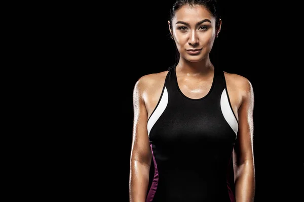 Eine starke athletische Frau mit schwarzem Hintergrund, die Sportbekleidung, Fitness und Sportmotivation trägt. — Stockfoto