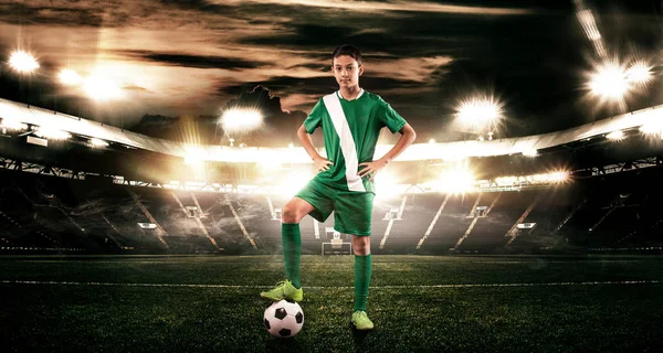 Мальчик - футболист. Мальчик вперед в футбольной спортивной одежде на стадионе с мячом. Концепция . — стоковое фото