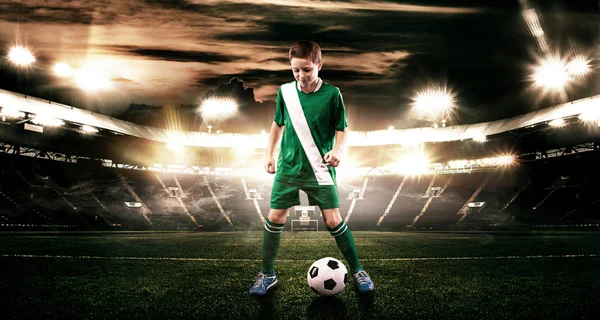 Kid - voetballer. Jongen uit in voetbal sportkleding op stadion met bal. Sport concept. — Stockfoto