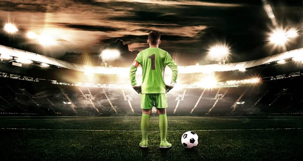 Niño - jugador de fútbol. Niño adelante en ropa deportiva de fútbol en el estadio con pelota. Concepto deportivo . — Foto de Stock