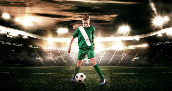 Dziecko - gracz piłki. Chłopiec do przodu w sportowej piłki nożnej na stadionie z piłką. Pojęcie sportu. — Zdjęcie stockowe
