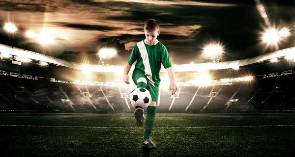Παιδί - παίκτης ποδοσφαίρου. Αγόρι εμπρός σε αθλητικά είδη ποδοσφαίρου στο γήπεδο με μπάλα. Η έννοια άθλημα. — Φωτογραφία Αρχείου