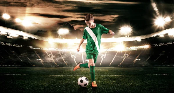 Niño - jugador de fútbol. Niño adelante en ropa deportiva de fútbol en el estadio con pelota. Concepto deportivo . — Foto de Stock