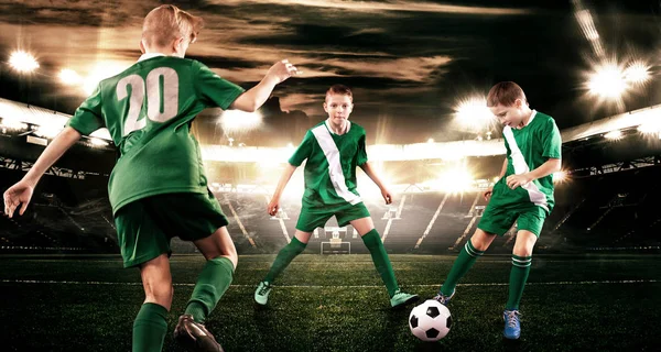 孩子-足球运动员男孩向前在橄榄球运动服在体育场与球。体育概念. — 图库照片
