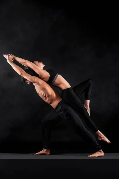 Acroyoga. Genç çift Acro yoga mat Studio birlikte uygulamak. Çift yoga. Ortak yoga. Siyah ve beyaz fotoğraf. — Stok fotoğraf
