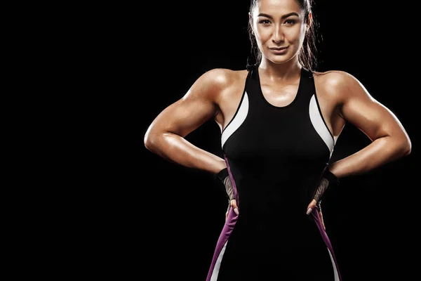 Una fuerte atlética, mujer sobre fondo negro que lleva en la ropa deportiva, fitness y motivación deportiva . —  Fotos de Stock