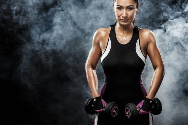 Sportovní krásná žena s činky dělá fitness cvičení na černém pozadí, aby zůstali fit — Stock fotografie