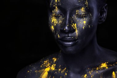 Sanat moda makyaj ile neşeli genç Afrikalı kadın. Bir kadın siyah makyaj ile şaşırtıcı ve sarı boya sızıntı