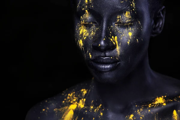 Yellow and black body paint. Woman with face art. Young girl with