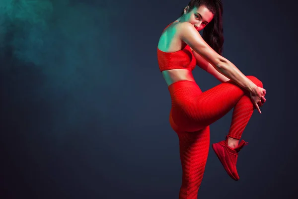 一个强壮的运动, 女人舞者, 摆在红色背景穿着运动服, 健身和运动动机与复制空间. — 图库照片