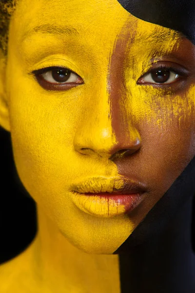 Wesoły młoda kobieta Afrykańska sztuka moda makijażu. Niesamowite kobieta z czarnej i żółtej farby makijaż — Zdjęcie stockowe