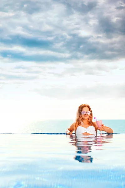 Zomervakantie. Vrouw in bikini op de opblaasbare donut matras in het zwembad van Spa. — Stockfoto
