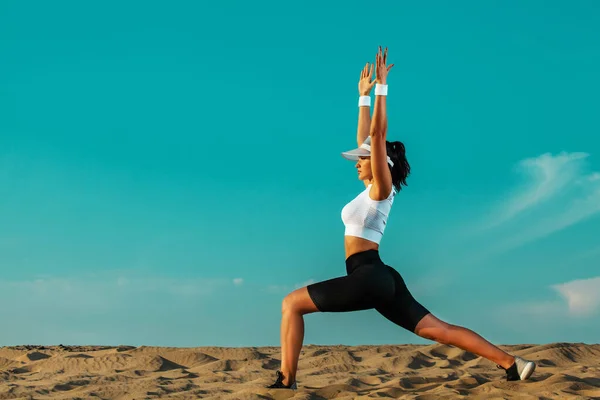 Deportiva y en forma atleta joven haciendo entrenamiento de yoga en el fondo del cielo. El concepto de un estilo de vida saludable y el deporte. Recreación deportiva individual . — Foto de Stock