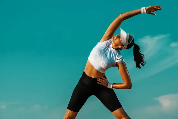 Ricreazione sportiva individuale. Sportiva e in forma giovane atleta donna facendo allenamento di yoga sullo sfondo del cielo. Il concetto di uno stile di vita sano e di sport . — Foto Stock