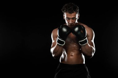 Boksör, siyah arka planda dövüşen ya da poz veren adam. Fitness ve boks konsepti. Bireysel spor eğlencesi.
