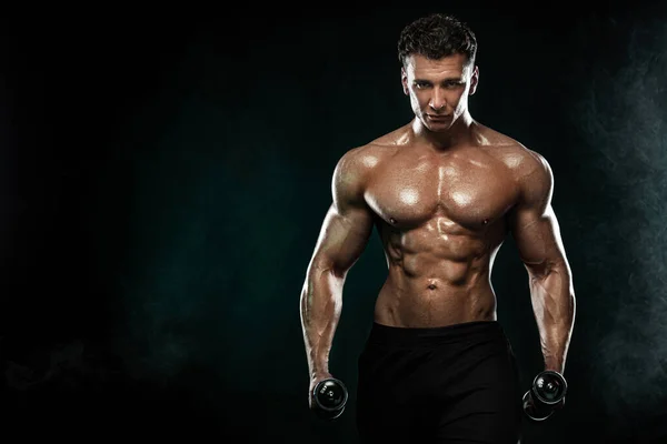 Bodybuilder uomo forte e in forma. Un tipo muscoloso e sportivo con i manubri. Sport e motivazione al fitness. Attività ricreative sportive individuali . — Foto Stock