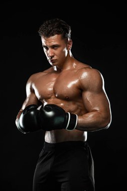 Boksör, siyah arka planda dövüşen ya da poz veren adam. Fitness ve boks konsepti. Bireysel spor eğlencesi.