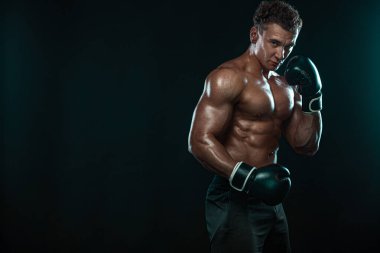 Boksör, siyah arka planda dövüşen ya da poz veren adam. Fitness ve boks konsepti. Bireysel spor eğlencesi.