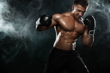 Boksör, siyah arka planda dövüşen ya da poz veren adam. Fitness ve boks konsepti. Bireysel spor eğlencesi.