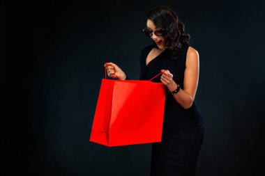 Kara Cuma mağaza satış konsepti. Güneş gözlüklü bir kadının elinde kırmızı bir çanta vardı..