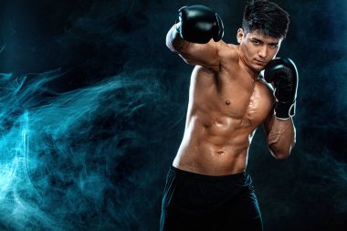 Fitness ve boks konsepti. Boksör, siyah arka planda dövüşen ya da poz veren adam. Bireysel spor eğlencesi.