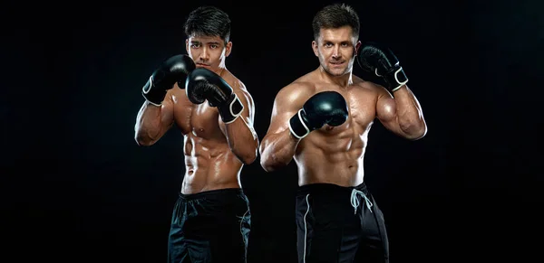 Boxer. Due combattenti maschi in guantoni da boxe in rastrelliere da combattimento su sfondo nero. Concetto fitness. Attività ricreative sportive individuali . — Foto Stock