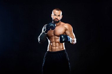 Fitness ve boks konsepti. Boksör, siyah arka planda dövüşen ya da poz veren adam. Bireysel spor eğlencesi.