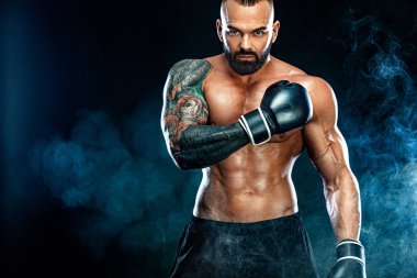 Fitness ve boks konsepti. Boksör, siyah arka planda dövüşen ya da poz veren adam. Bireysel spor eğlencesi.