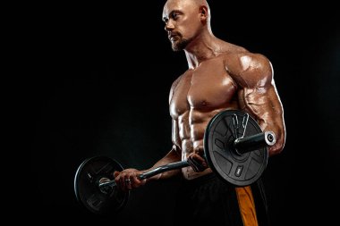 Güçlü ve zinde adam vücut geliştirmeci. Barbell'li sportif kaslı adam. Spor ve fitness motivasyonu. Bireysel spor rekreasyon.