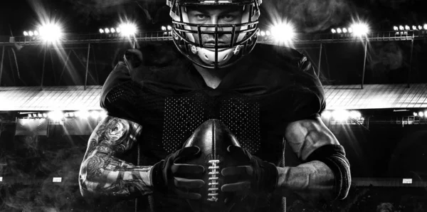 Conceito desportivo. Desportista de futebol americano no fundo escuro com luzes. Conceito de desporto . — Fotografia de Stock