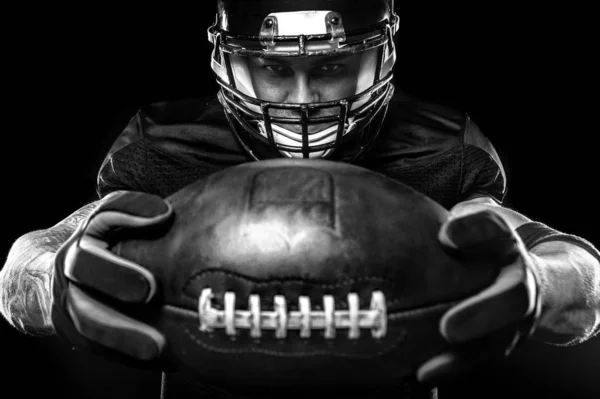 Conceito desportivo. Desportista de futebol americano no fundo preto. Conceito de desporto . — Fotografia de Stock