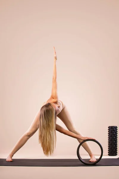 Clases de yoga en interiores. Recreación deportiva. Hermosa joven en pose asana. Deportes individuales. Ropa deportiva desnuda . — Foto de Stock