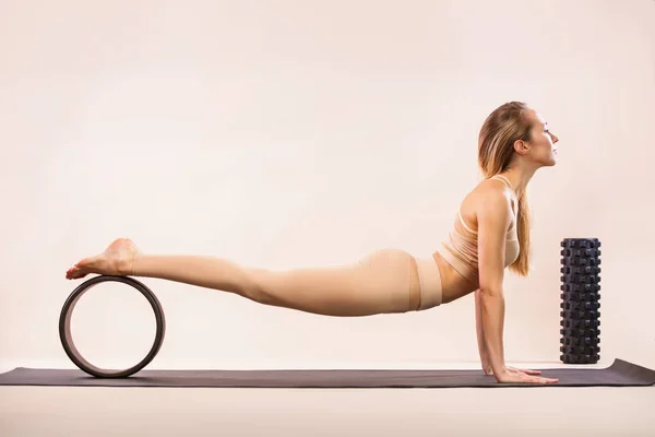 Clases de yoga en interiores. Recreación deportiva. Hermosa joven en pose asana. Deportes individuales. Ropa deportiva desnuda . — Foto de Stock