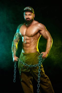 Çıplak gövdeli eşcinsel streptizör. Kaslı fitness sporcusu, spor salonunda zincirli atlet. Enerji ve güç..