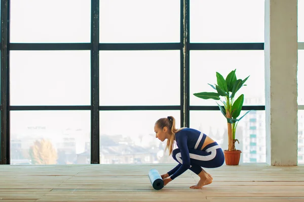 Yoga asana Interior antes de uma grande janela panorâmica. Recreação desportiva. Mulher bonita em pose de ioga. Esportes individuais . — Fotografia de Stock