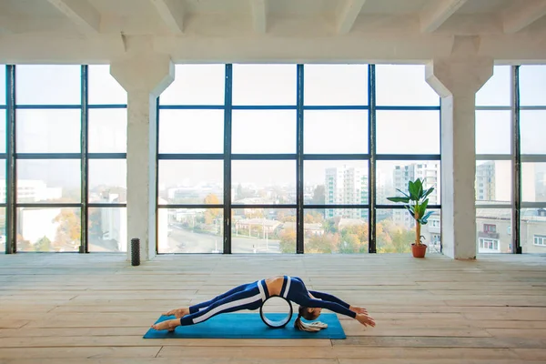 Yoga asana Interior ante una gran ventana panorámica. Recreación deportiva. Hermosa joven en pose de yoga. Deportes individuales . —  Fotos de Stock