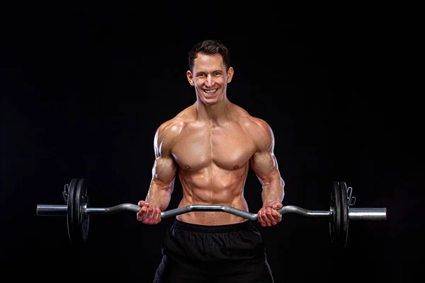 Athlete bodybuilder. Brutal strong muscular athletic man pumping up muscles with barbell on black background. Workout bodybuilding concept. — Stock Photo, Image