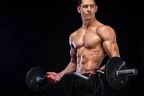 Athlete bodybuilder. Brutal strong muscular athletic man pumping up muscles with barbell on black background. Workout bodybuilding concept. — Stock Photo, Image