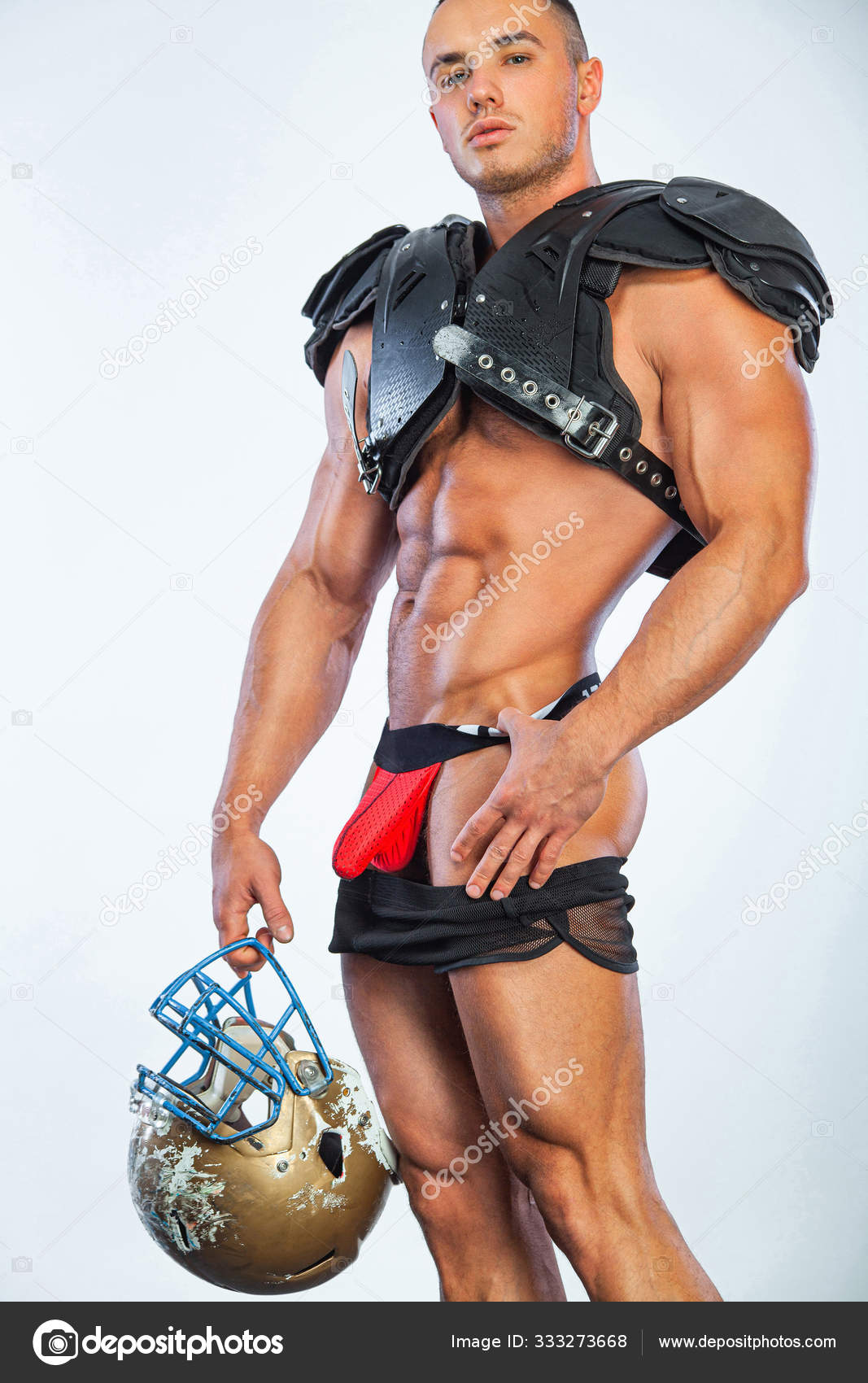 Gay streptizer with naked torso. American football player in helmet isolated on white background