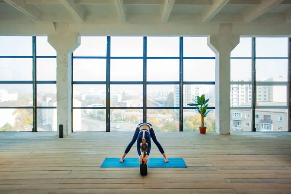 Yoga asana Interior ante una gran ventana panorámica. Recreación deportiva. Hermosa joven en pose de yoga. Deportes individuales . —  Fotos de Stock