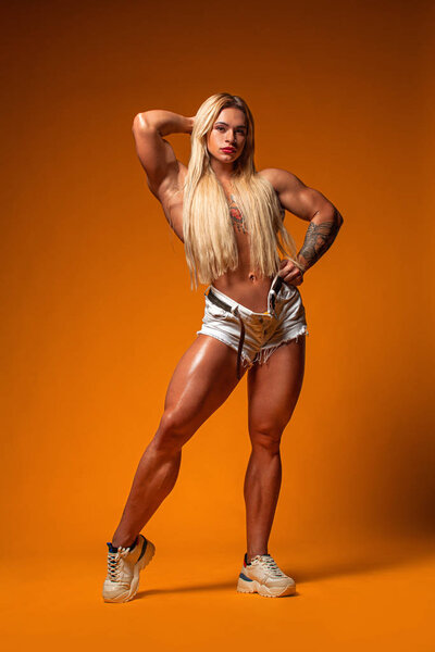 Athlete bodybuilder. Strong athletic woman on steroids on yellow background. Fitness and sport motivation.
