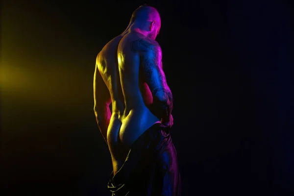 Svalnatý mladý sexy hezký muž kulturista izolované na černém pozadí. Překvapený gay streptizer s nahým trupem. Filtry barev. — Stock fotografie