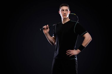 Badminton oyuncusu spor giyim sektöründe raket ve siki siyah arka planda. Olimpiyat oyunu.