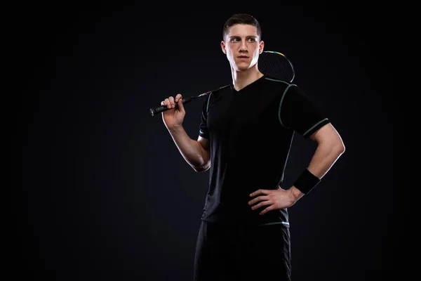 Badminton player in sportswear with racket and shuttlecock on black background. Olympic game. — 스톡 사진