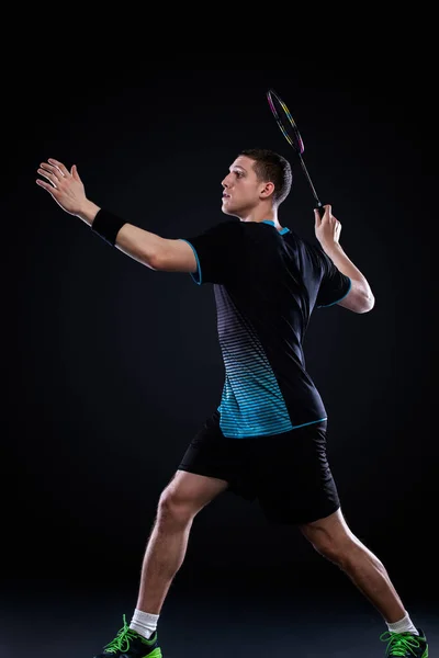 Badmintonspieler in Sportbekleidung mit Schläger und Federball auf schwarzem Hintergrund. Olympisches Spiel. — Stockfoto