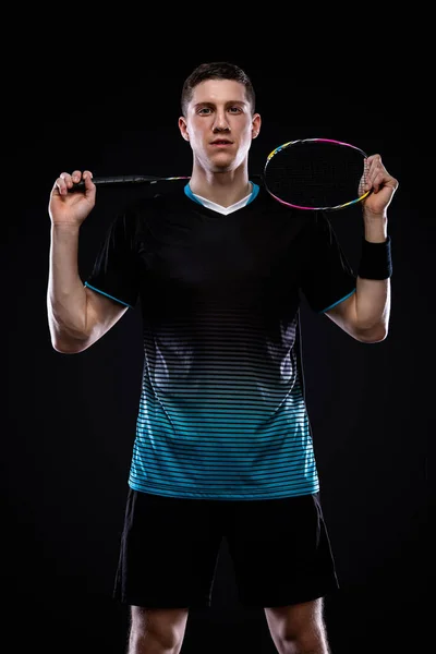 Badminton player in sportswear with racket and shuttlecock on black background. Olympic game. — Stock Photo, Image