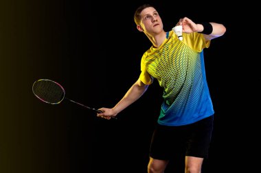 Badminton oyuncusu spor giyim sektöründe raket ve siki siyah arka planda. Bireysel sporlar. Spor eğlencesi..